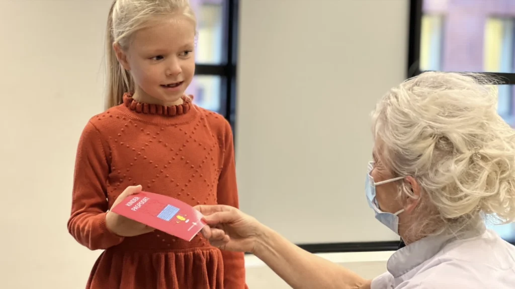 Meisje ontvangt het Kinderpaspoort van een verpleegkundige in het Jeroen Bosch Ziekenhuis