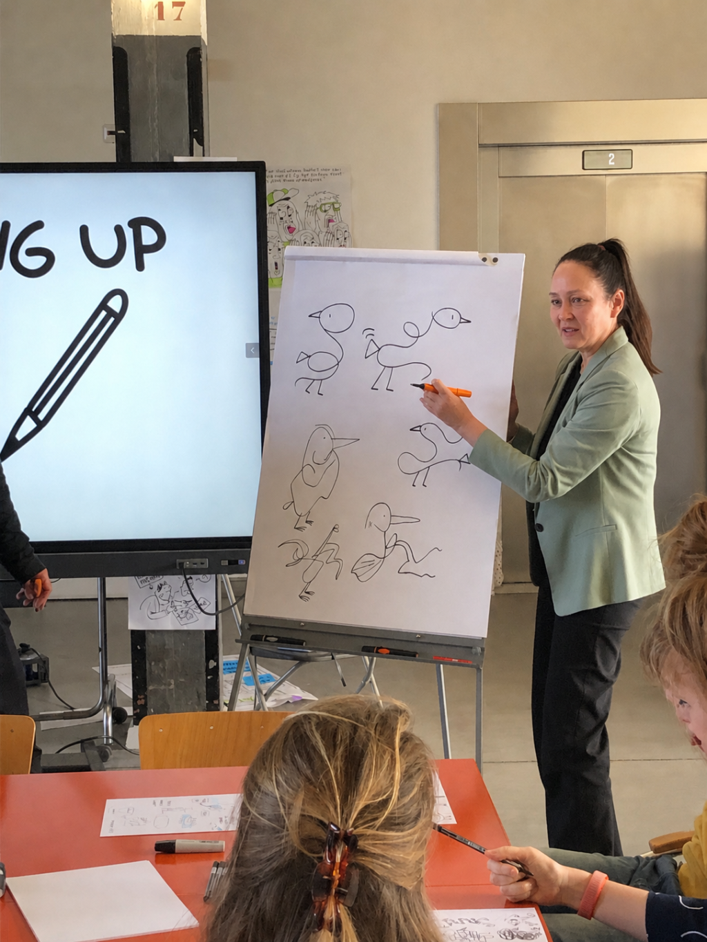 Trainer geeft uitleg bij een flip-over met simpele tekeningen tijdens de workshop