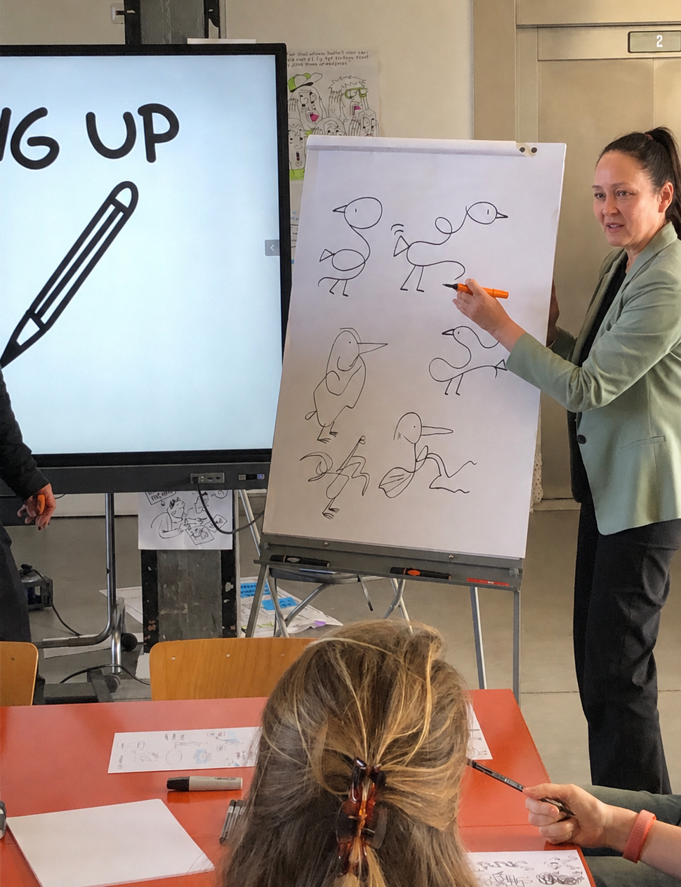 Trainer geeft uitleg bij een flip-over met simpele tekeningen tijdens de workshop