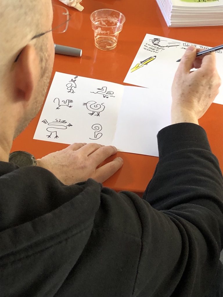 Deelnemer oefent met simpele tekeningen van vogels tijdens de workshop